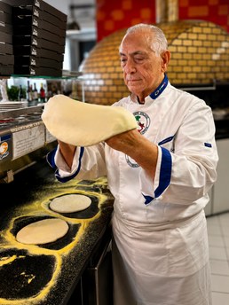 Chef a abrir a massa da pizza à mão