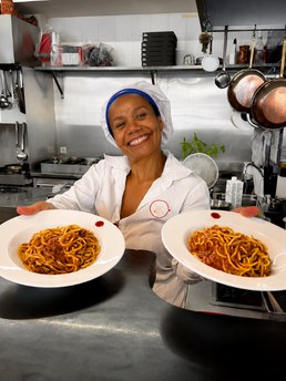 Cozinheira a servir dois pratos de massa