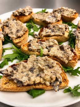 Bruschetta com creme de cogumelos e rúcula